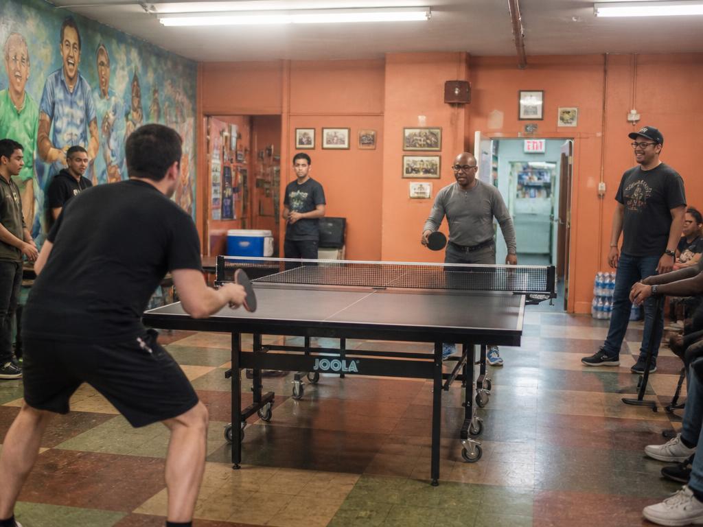 Men playing ping pong in the community rec room